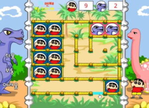 착한 공룡을 도와주자 짱구교실 게임에서 공룡 배경 맵 위에 짱구 얼굴 타일과 공룡 타일이 길 모양으로 배치되고 오른쪽 아래 짱구가 서 있는 가운데 상단에는 짱구와 공룡 점수가 표시된다.