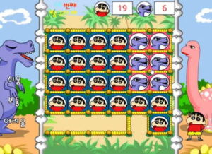 착한 공룡을 도와주자 짱구교실 게임에서 공룡 배경 맵 위에 짱구 얼굴 타일이 가득 채워지고 상단에는 짱구와 공룡 점수가 표시된 가운데 오른쪽 아래 짱구가 통로 입구에 서 있다.